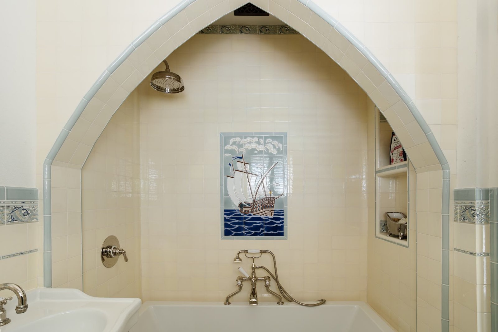 Tub niche under a pointed arch with a hand-painted ship tile mural