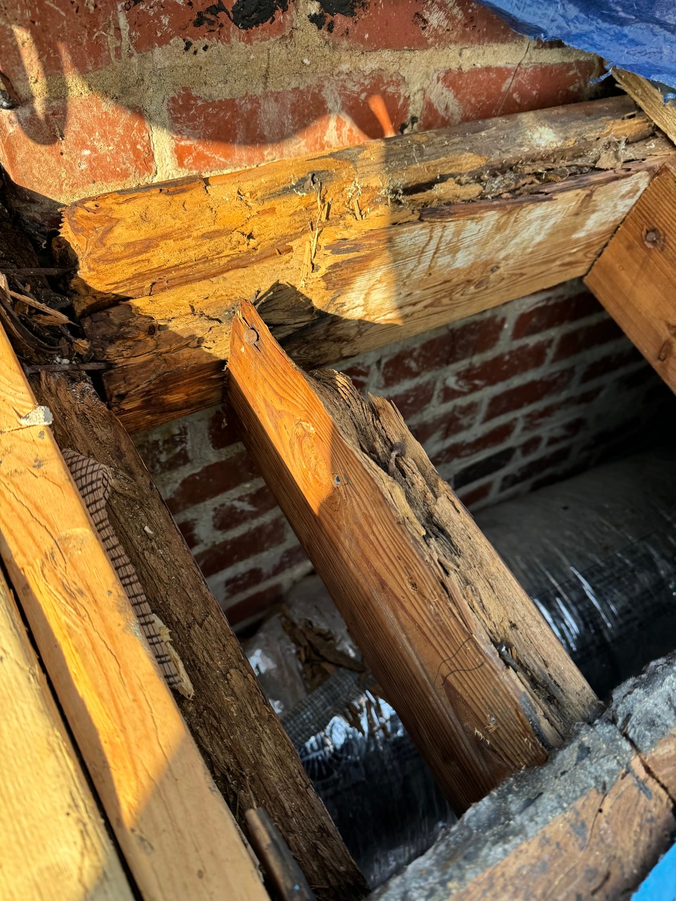 During: rotten rafters at the chimney. Historic houses hide this until the roof comes off.