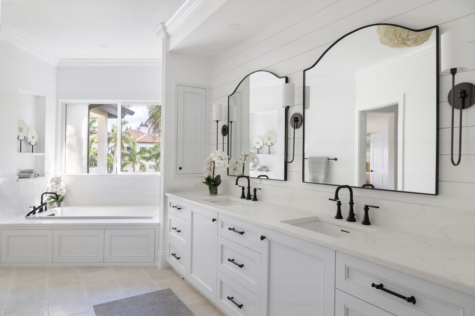 Primary bath double vanity with arched black-framed mirrors, shiplap, and white quartz