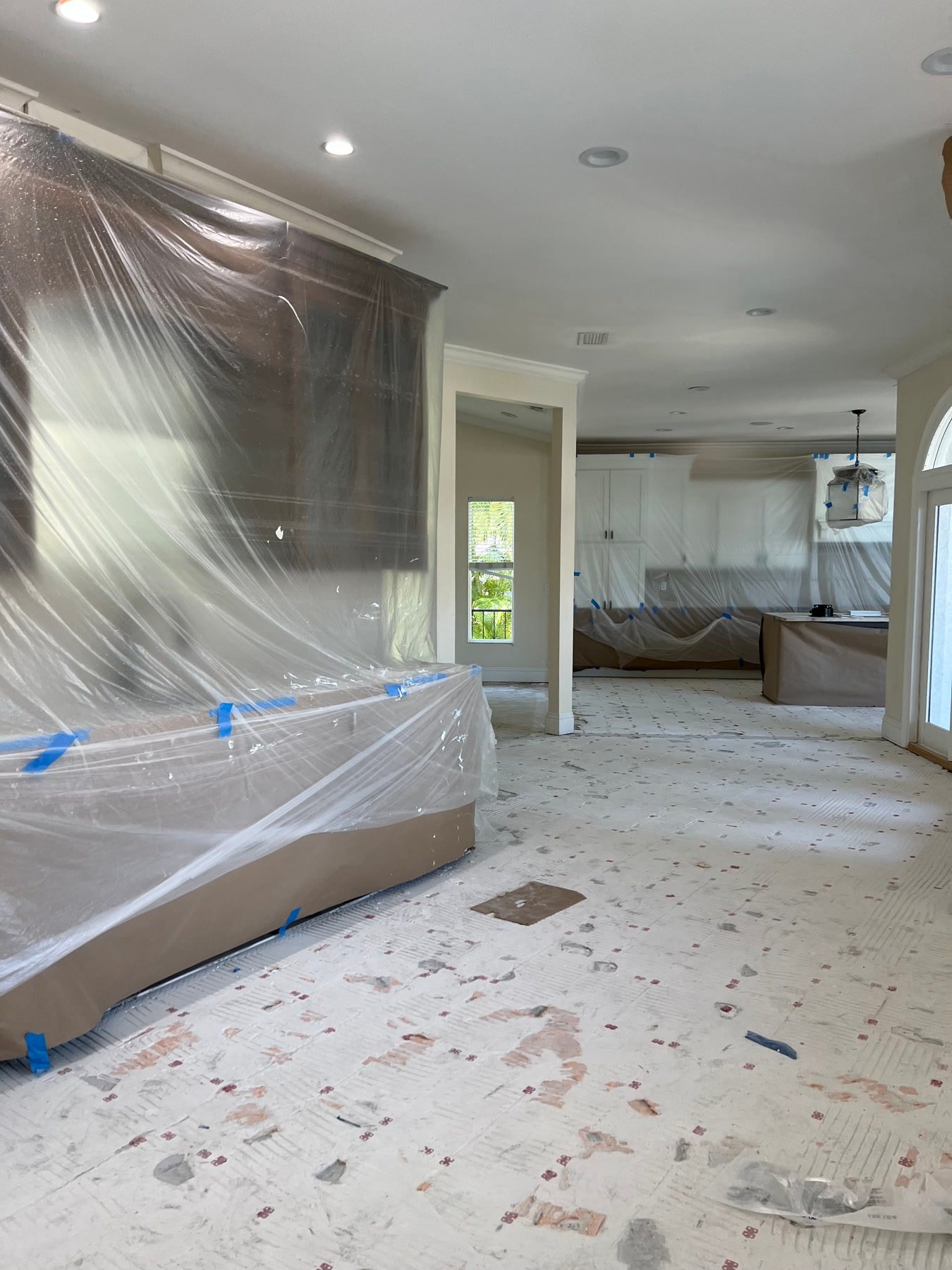 During: occupied-house protection while floors and paint move through the living rooms