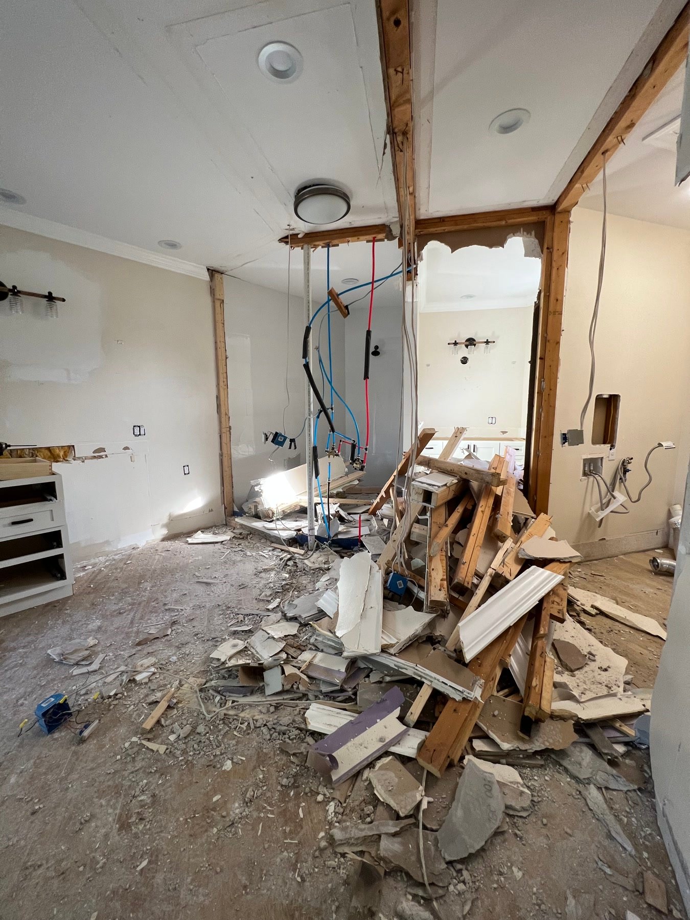 During: primary suite demolition — walls opened, plumbing dropped, rooms combined