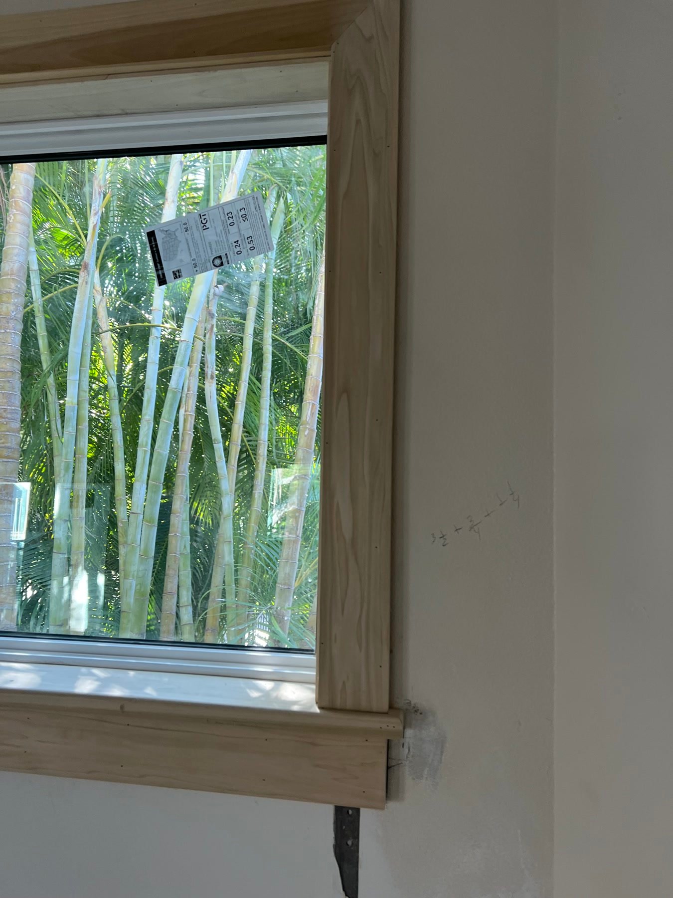 During: new PGT window with millwork casing being fit — the openings the house was missing