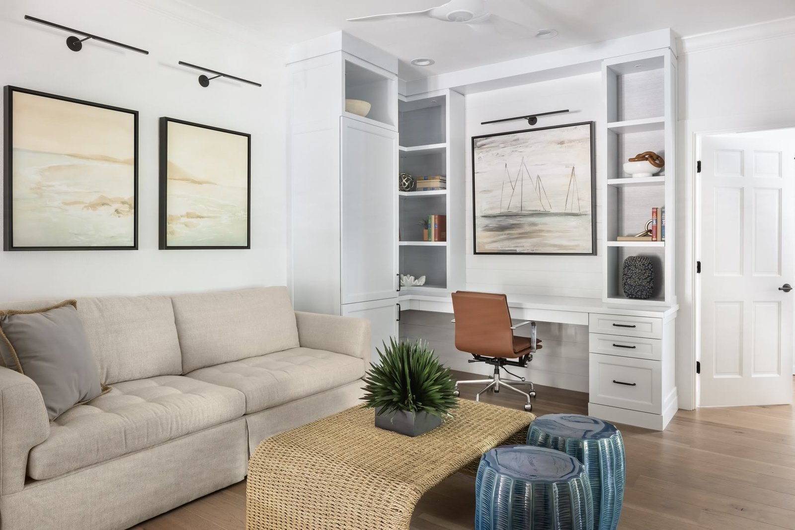 Built-in millwork office with shiplap, a leather chair, and a sail painting