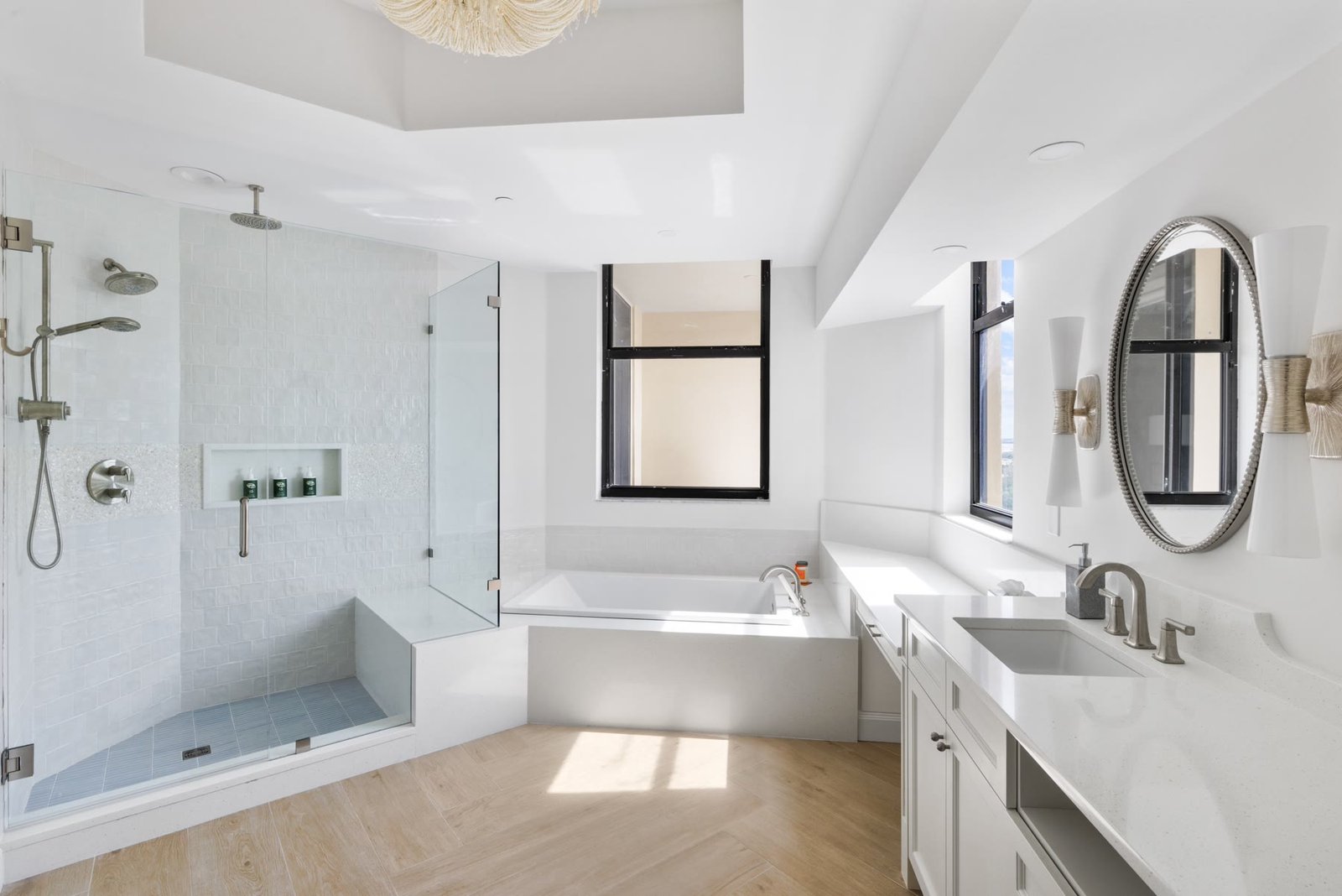 Reconfigured primary bath with a glass shower, soaking tub, and a long white vanity