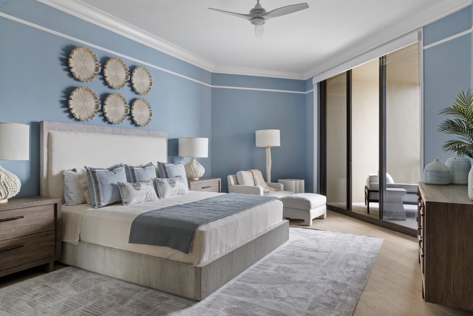 Primary bedroom in powder blue with a gulf-facing sitting area and sliding doors