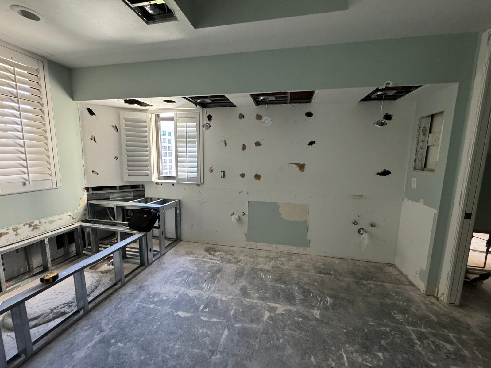 During: primary bath gutted — metal framing for the new vanity and walls opened