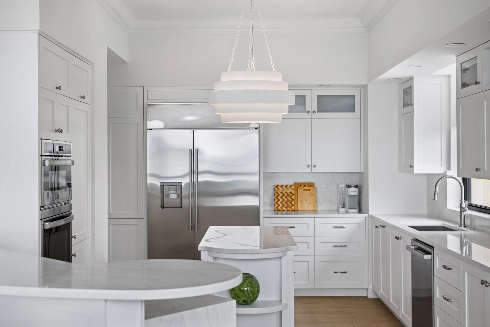 Kitchen millwork wrapping a professional refrigerator and stacked ovens