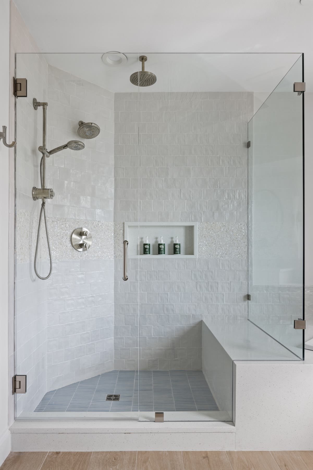 Walk-in shower with pearl tile, a rain head, and a built-in bench